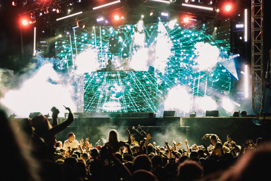 Planejamento de Viagens. — Vibrant music concert with DJ and crowd at night, showcasing lively atmosphere and dazzling